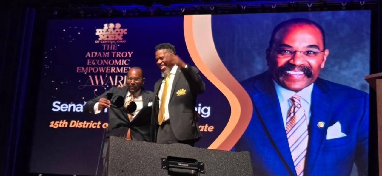 Senator Hearcel Craig smiling and holding an award