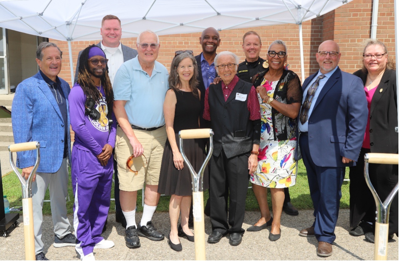 A group of people pose in front of a shovel at the Buddy LaRosa Center for Youth groundbreaking ceremony.